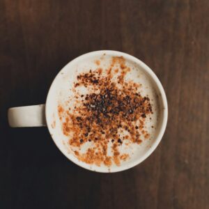 white ceramic mug on brown surface